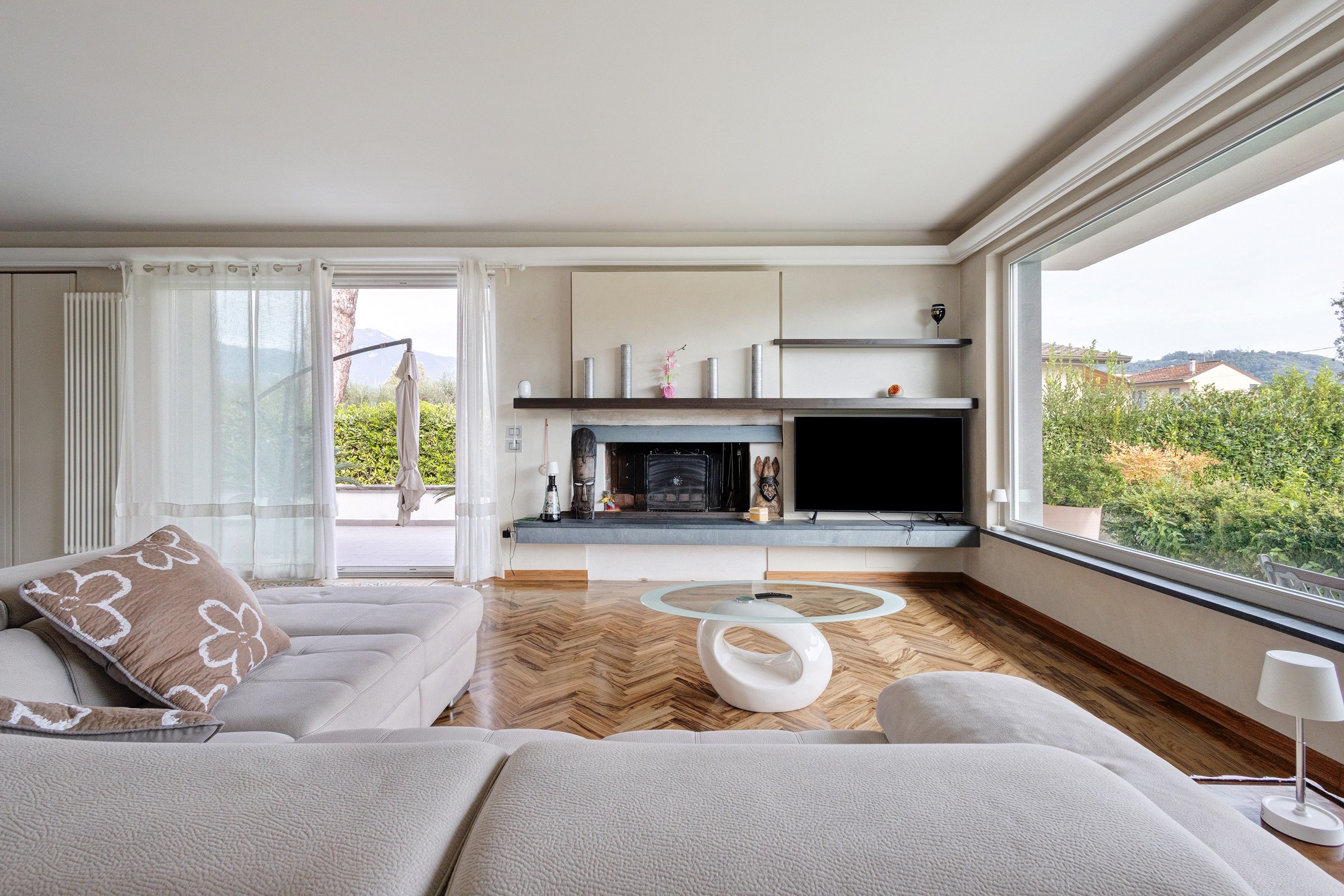 A modern living room with a fireplace, a sofa, a coffee table, and a television.