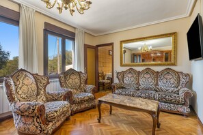 A room with a sofa set, a coffee table, and a large mirror.