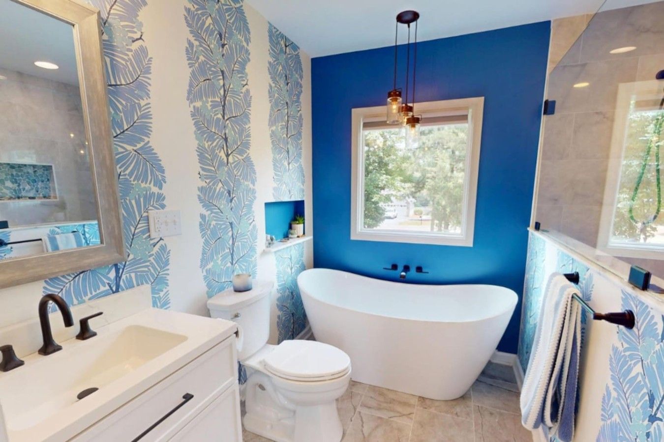 A bathroom with a freestanding bathtub, a toilet, and a sink with a mirror.
