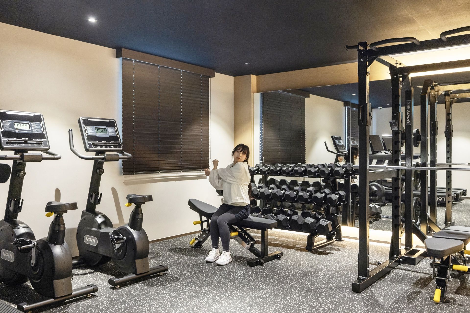 A gym with exercise equipment, including treadmills, dumbbells, and weight machines.