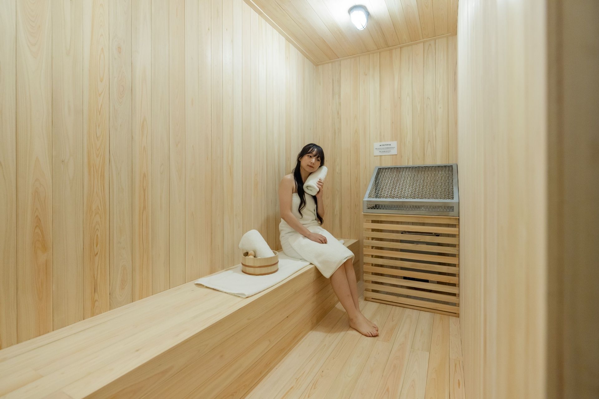 Una sala de sauna con paredes de madera y un banco.
