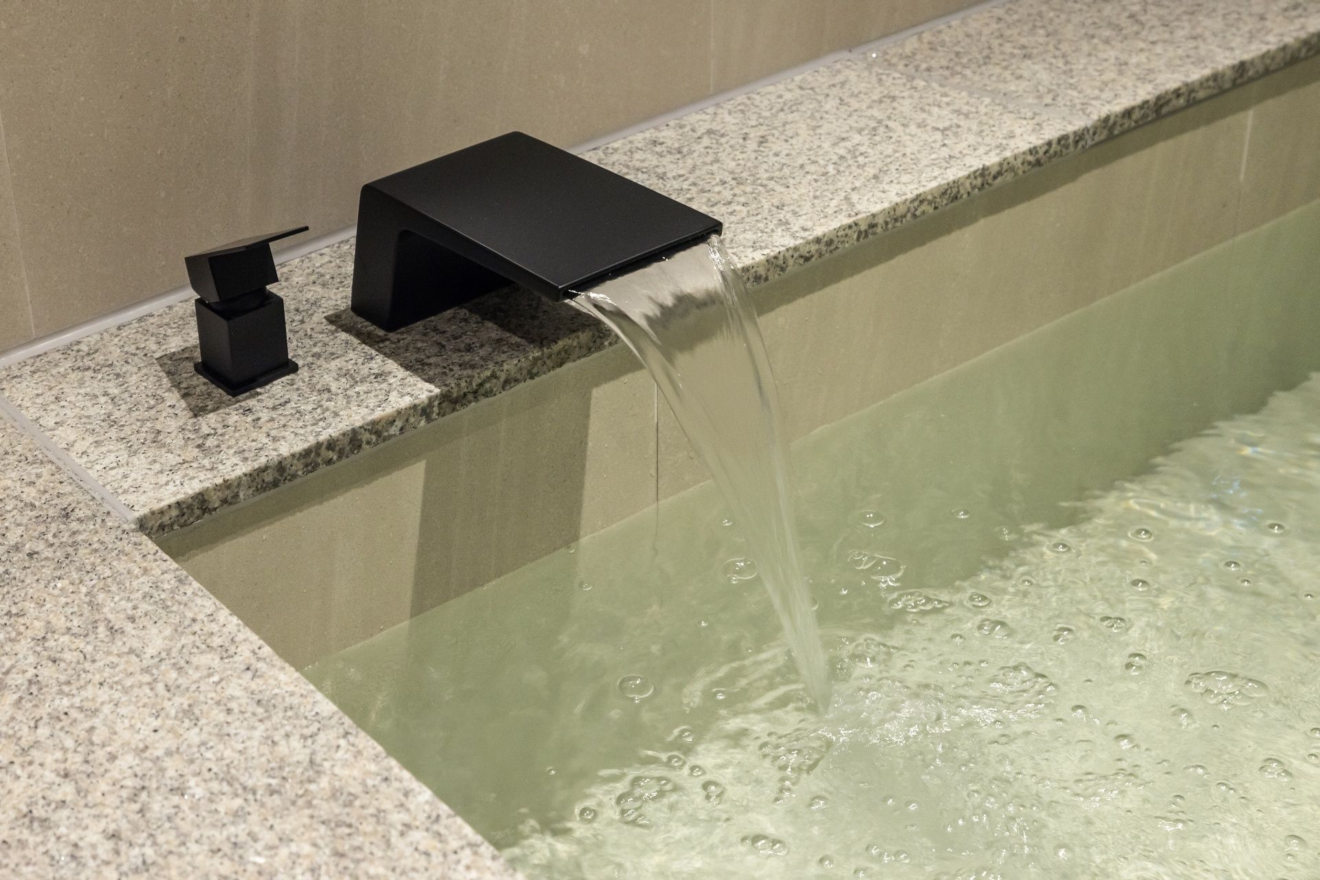 A modern bathroom with a rectangular sink and a faucet.