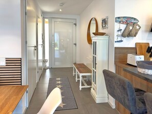 Eine moderne Küche mit einem Holztisch, einem weißen Schrank und einer Mikrowelle.