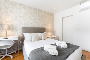 A hotel room with a bed, bedside tables, a desk, and a chair. - GuestReady - Cozy Retreat in Porto Center (Porto)