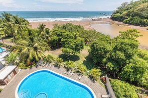 A swimming pool with a view of the beach and ocean. - Luxury Oceanfront 2-bedroom condo in enchanting Jacó on the Beach!!! (Jacó)