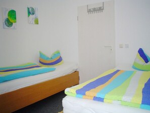 A room with two beds, each with a colorful striped blanket and matching pillows. - Park Residence Am Hafen 32 (Zingst)