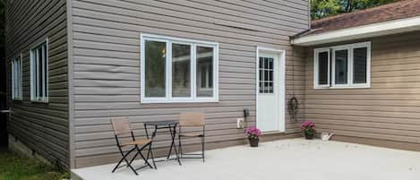 Une maison à deux étages dotée d’un patio couvert.