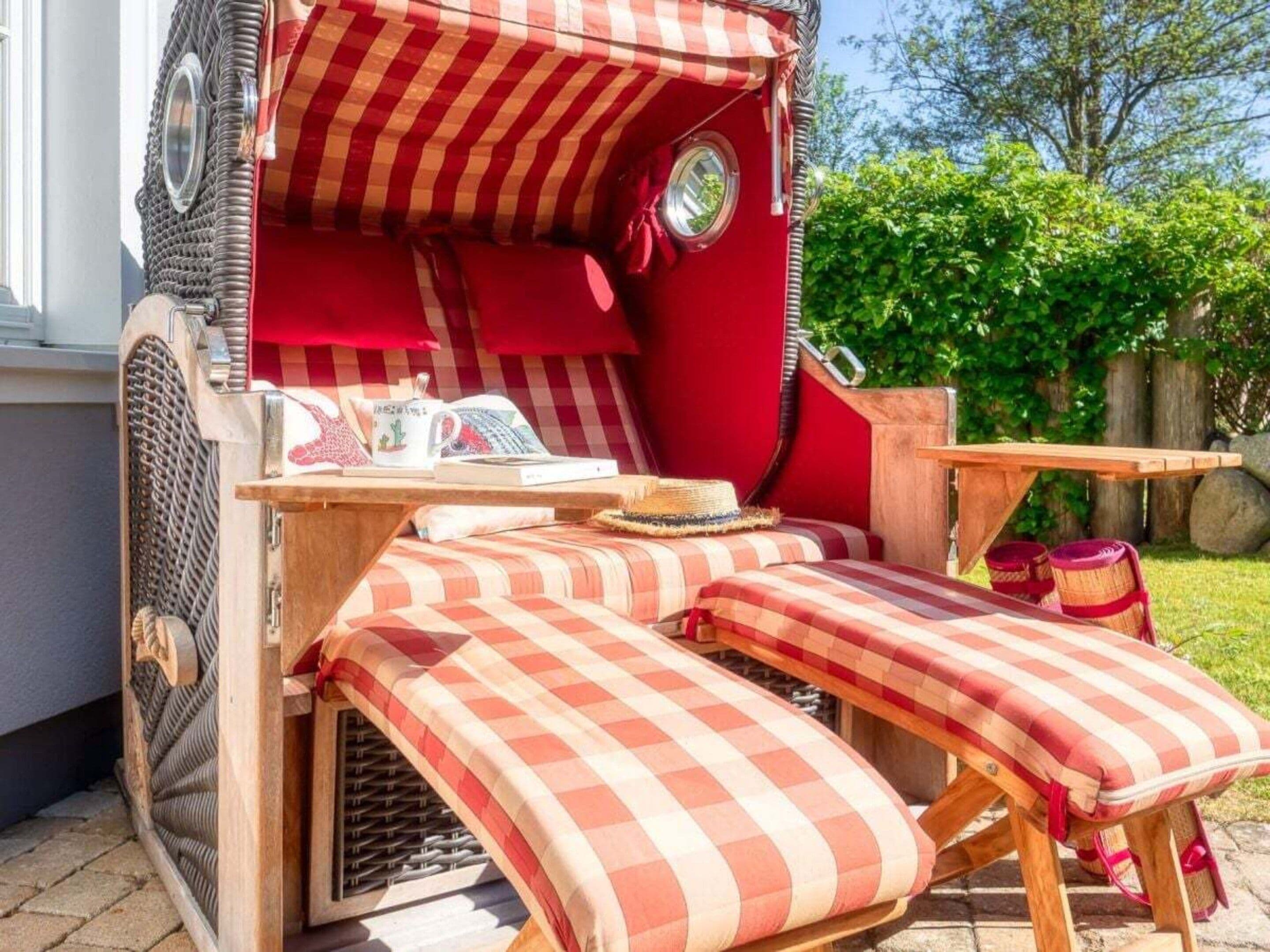 Ein gemütlicher Sitzbereich im Freien mit gestreiftem Kissen, einem Holztisch und einem Korbstuhl.