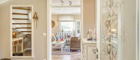 A spacious living area with a staircase, a sofa set, and a decorative cabinet.