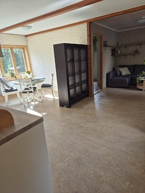 A spacious living area with a dining table, chairs, a black cabinet, and a sofa. - Forest Idyll in Jämtland Pure Peace & Nature (Fåker)