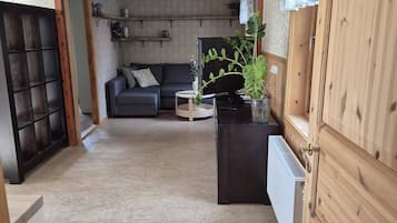 Una habitación con sofá, televisión, radiador y un mueble de madera.
