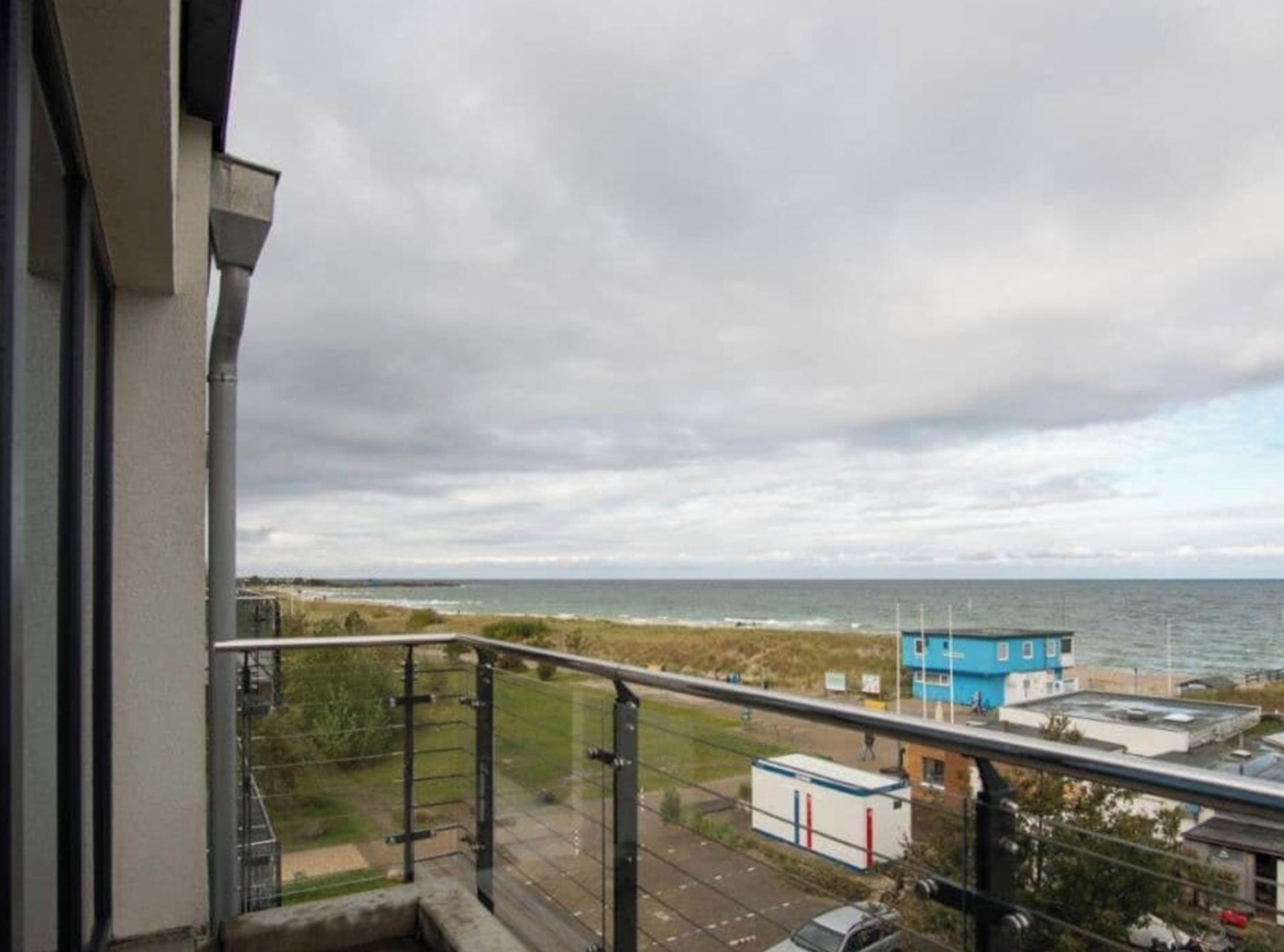 Ein Balkon mit Blick auf das Meer und eine Küstenstraße.