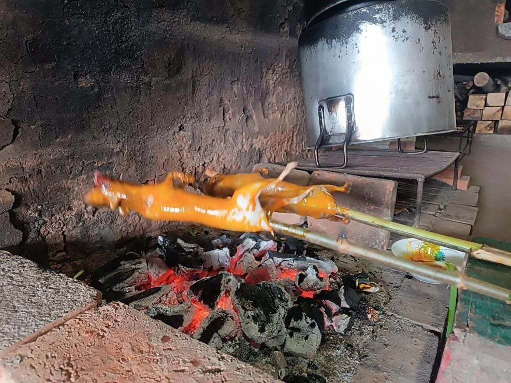 Preparación para cocinar con un asador giratorio sobre fuego abierto.