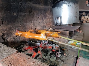 Preparación para cocinar con un asador giratorio sobre fuego abierto.
