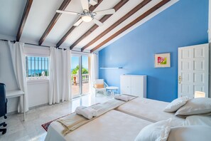 Ein Hotelzimmer mit Bett, Schreibtisch, Stuhl, Kleiderschrank und Blick ins Freie.