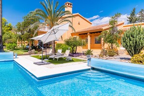 A swimming pool with lounge chairs and umbrellas, surrounded by a landscaped garden with palm trees and cacti. - Cubo's Villa Mirador del Mar Family / Private pool / Air conditioning / Sea views / Free Wi-Fi (Vélez Málaga)
