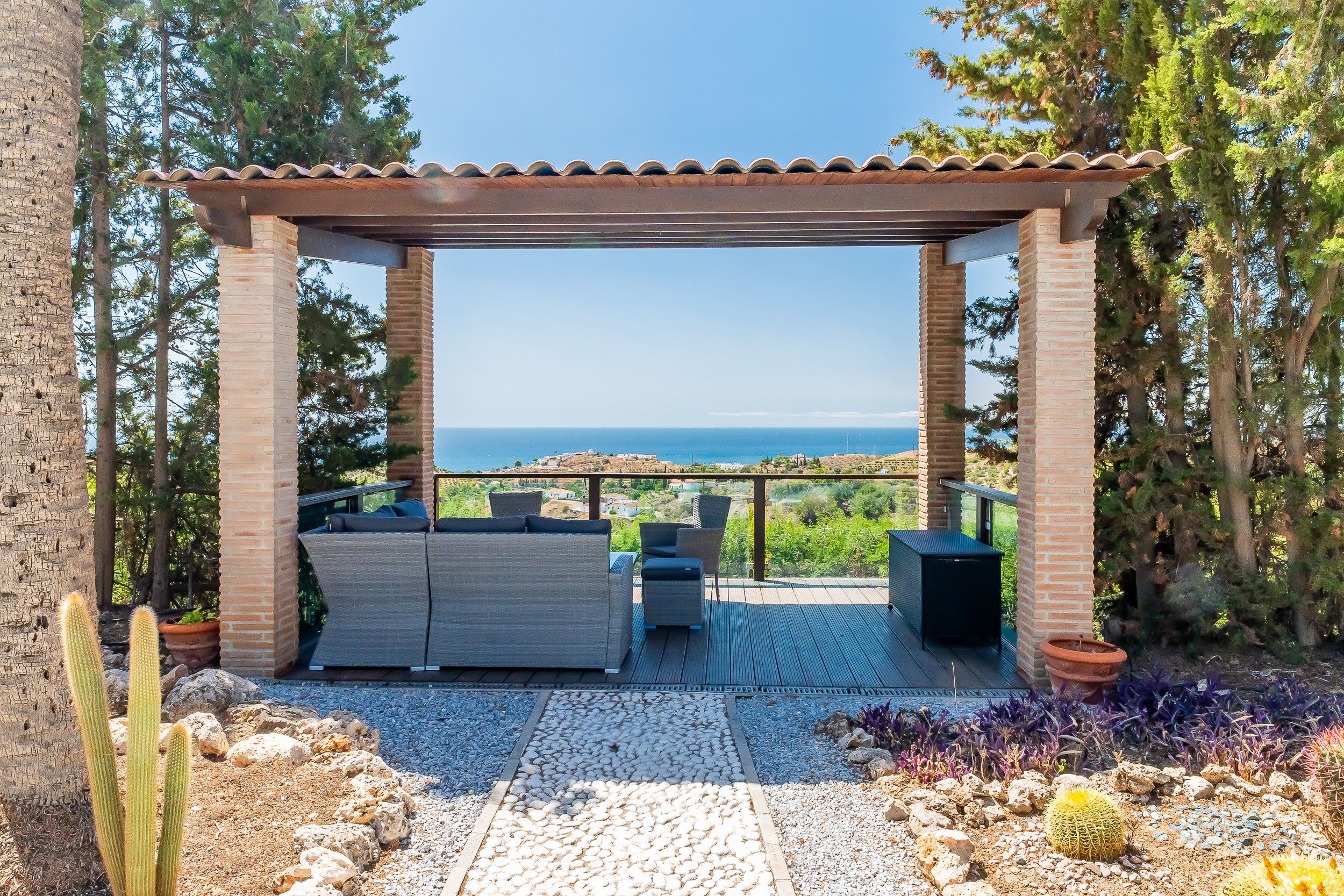 A covered outdoor seating area with a view of the sea.