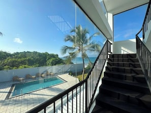 Une piscine avec vue sur l’océan et les palmiers.