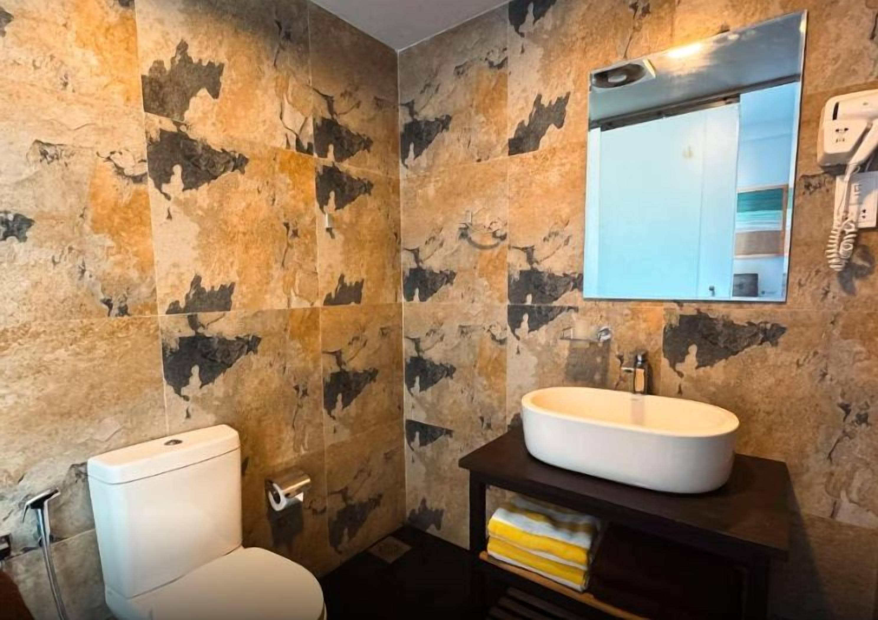 Un baño con inodoro, lavabo y espejo.