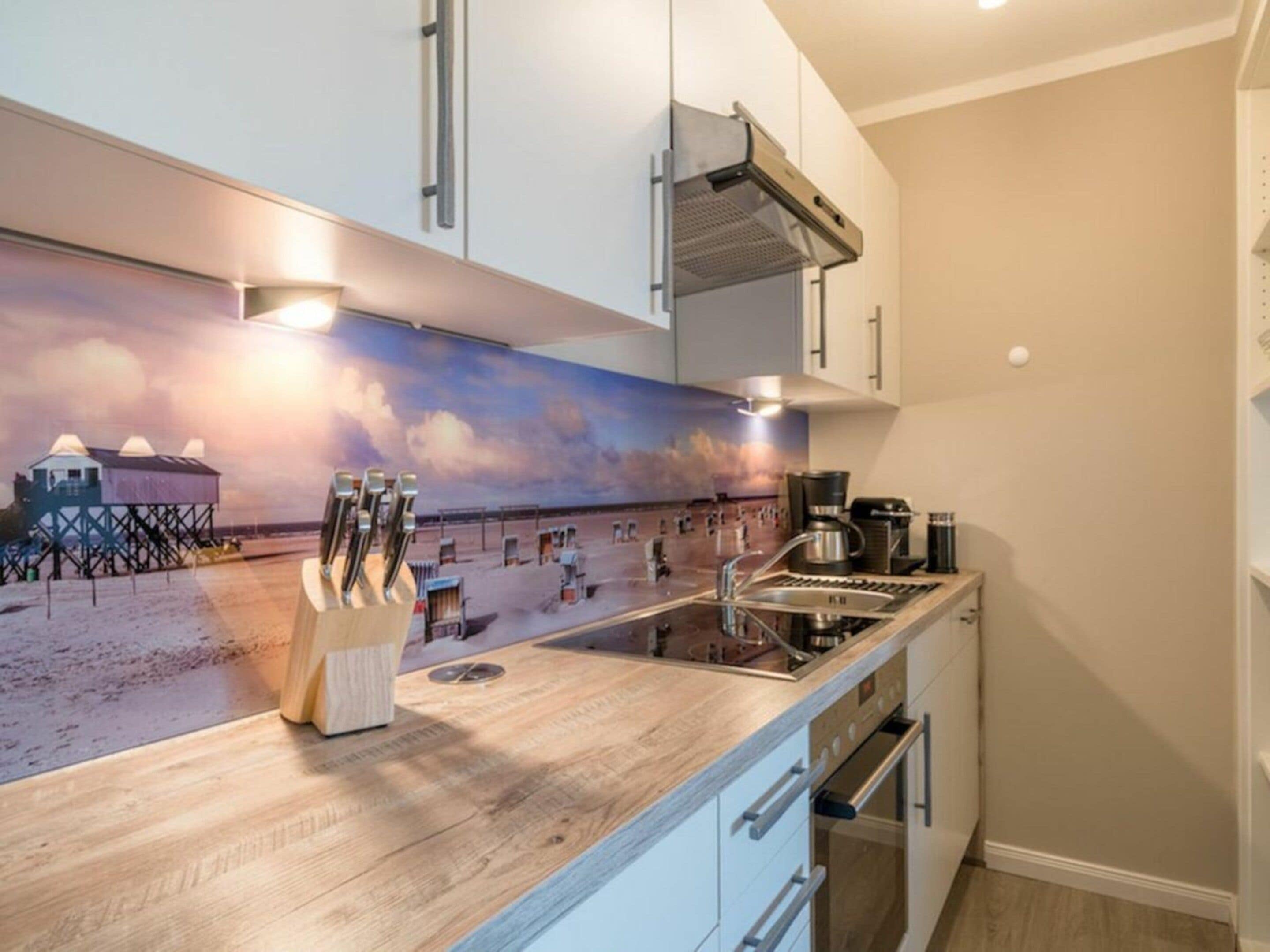 Una cocina con encimera de madera, cafetera y lavabo.