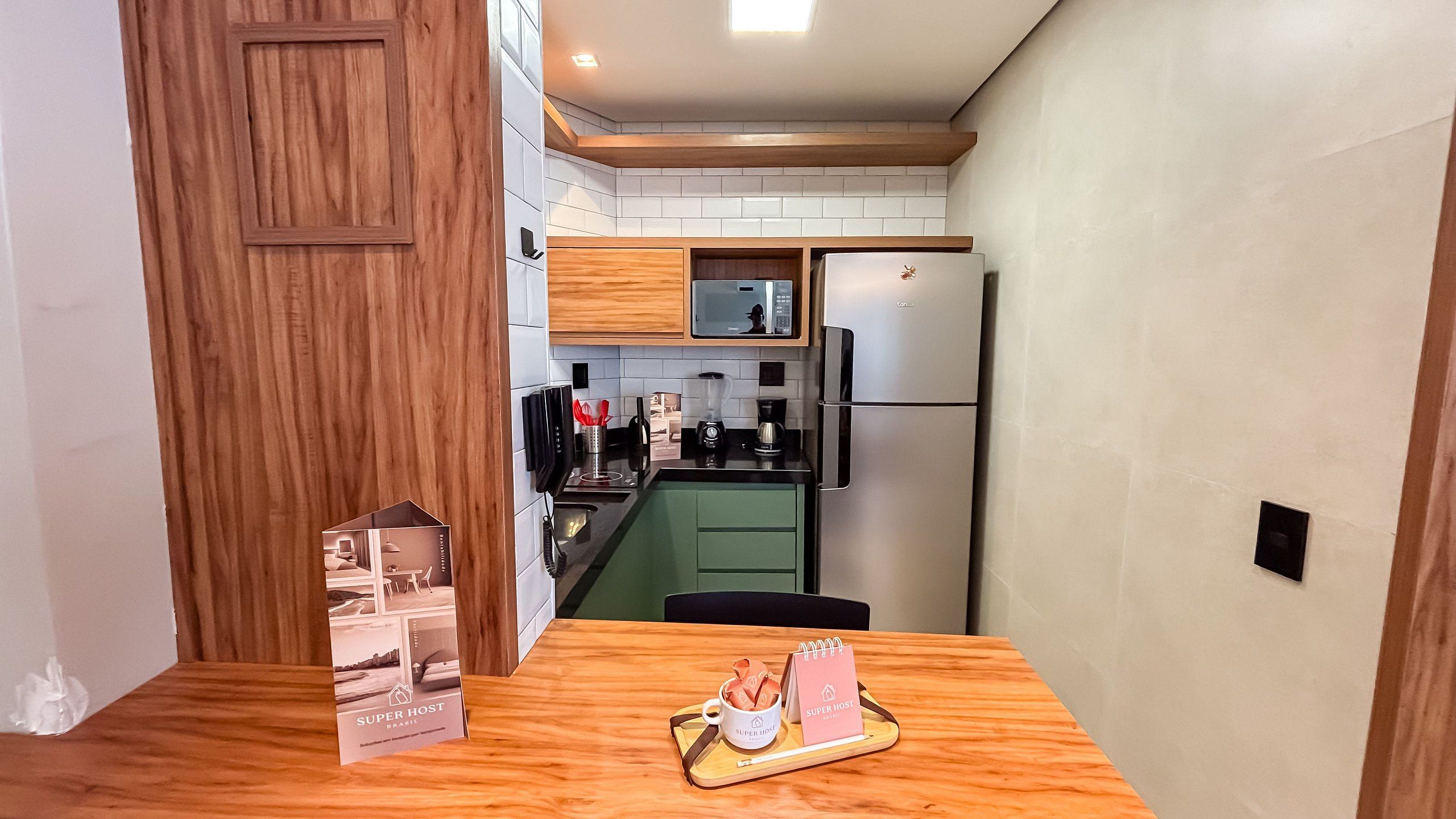 A compact kitchen with a microwave, coffee maker, and a refrigerator.