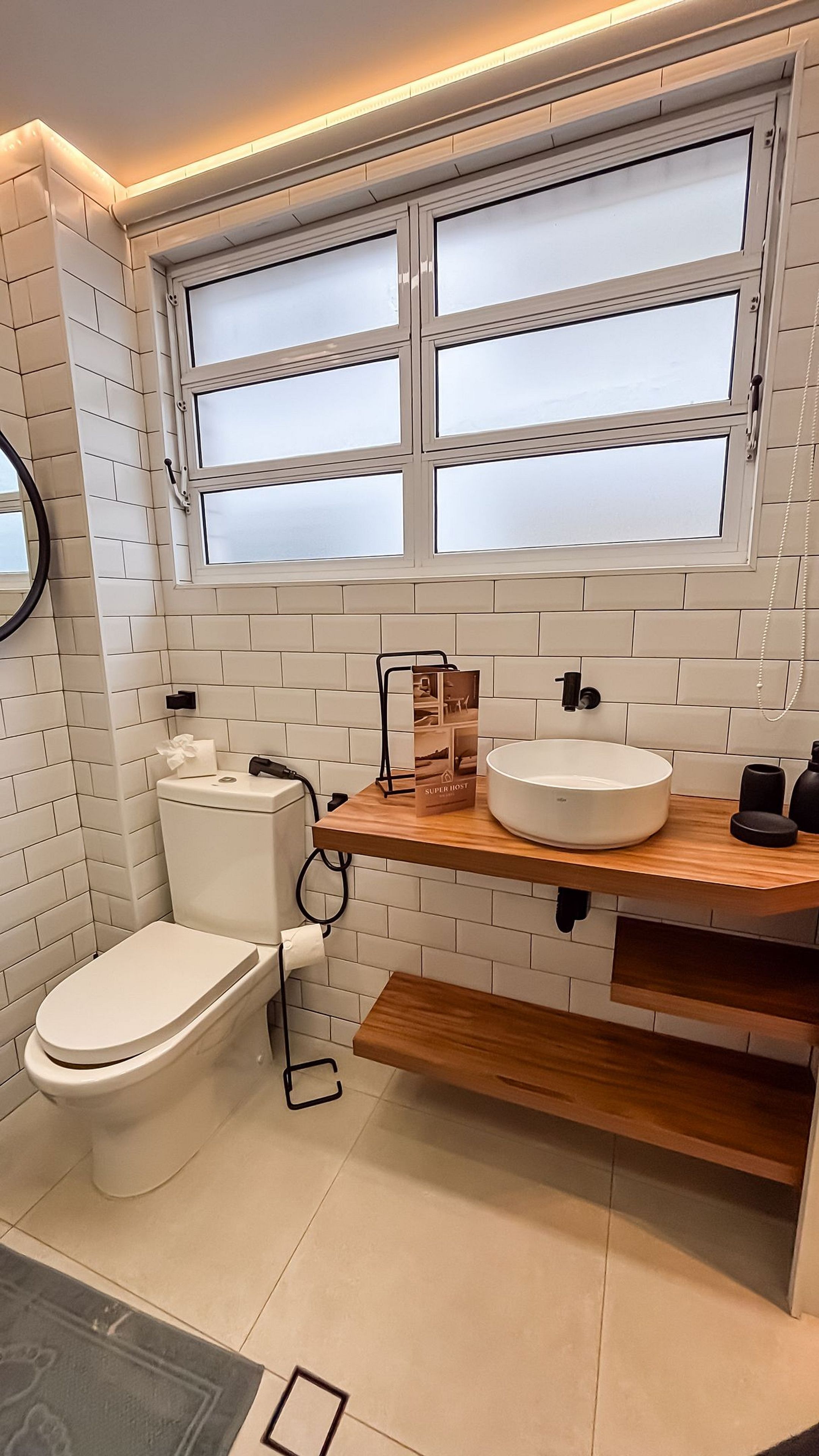 Un baño moderno con inodoro, lavamanos y ventana.