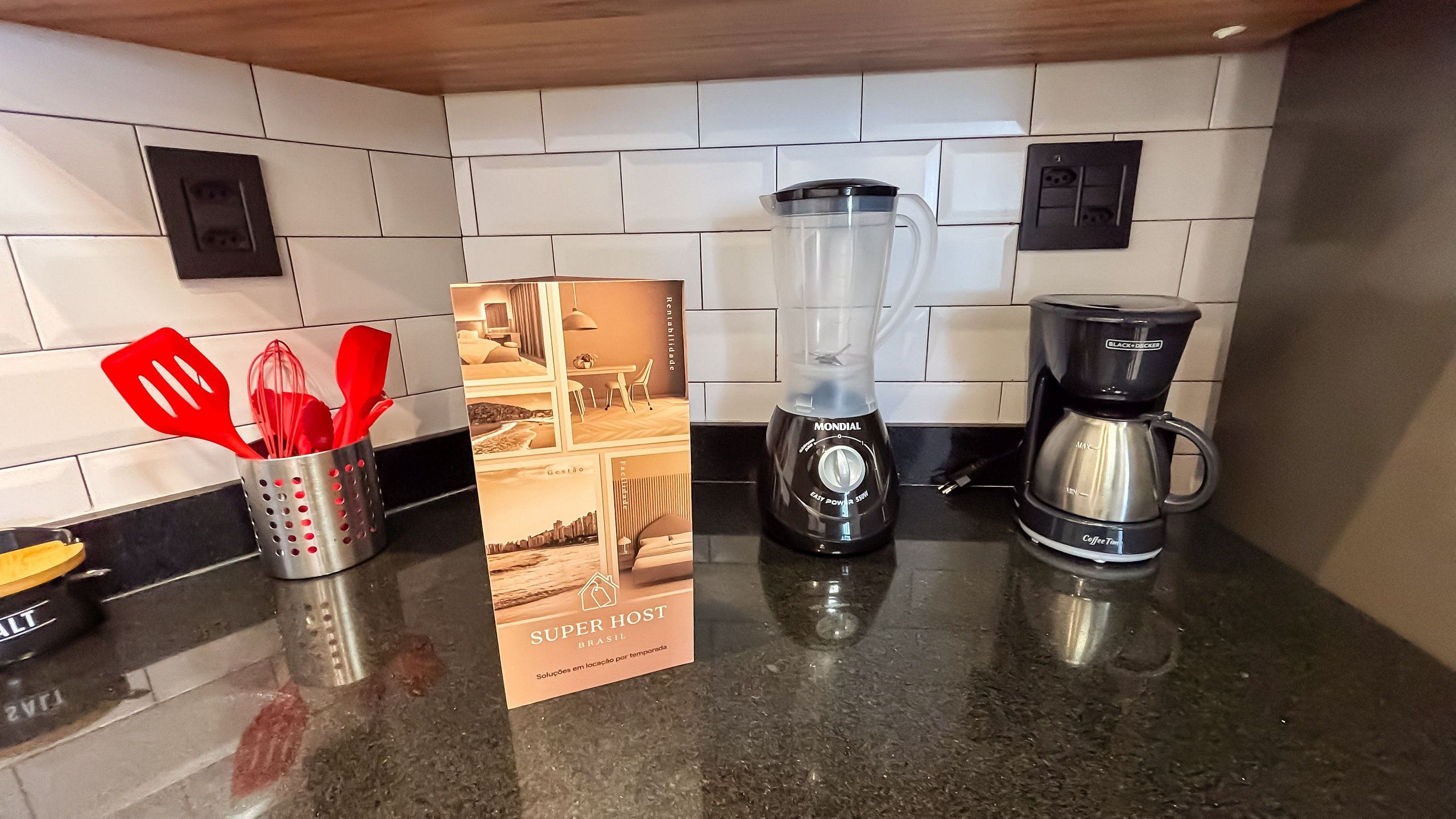 Una cucina con frullatore, macchina del caffè e un cartello che indica 'Super Host Brasil'.