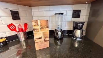 Una cucina con frullatore, macchina del caffè e un cartello che indica 'Super Host Brasil'.