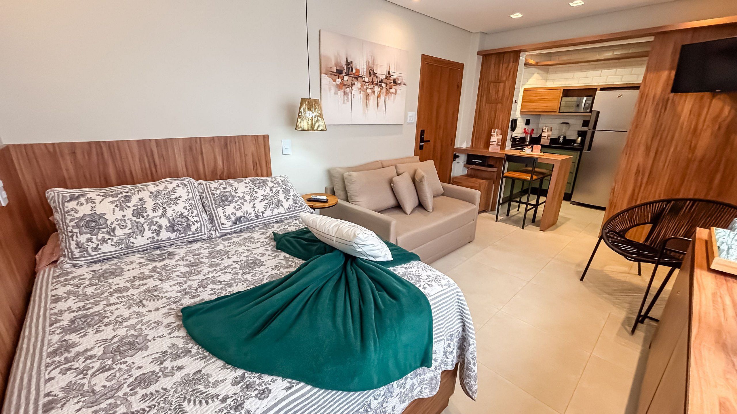 Una camera da letto moderna con un letto grande, un divano, un'area pranzo e una cucina.