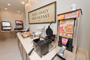 A breakfast station with waffle makers and a waffle dispenser. - Free Breakfast! 2BR Suite + Outdoor Pool Access (Humble)