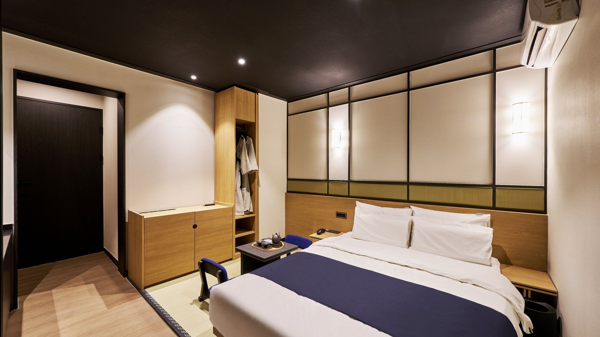 Een hotelkamer met een bed, nachtkastjes, een garderobe en een inbouwkleerkast.