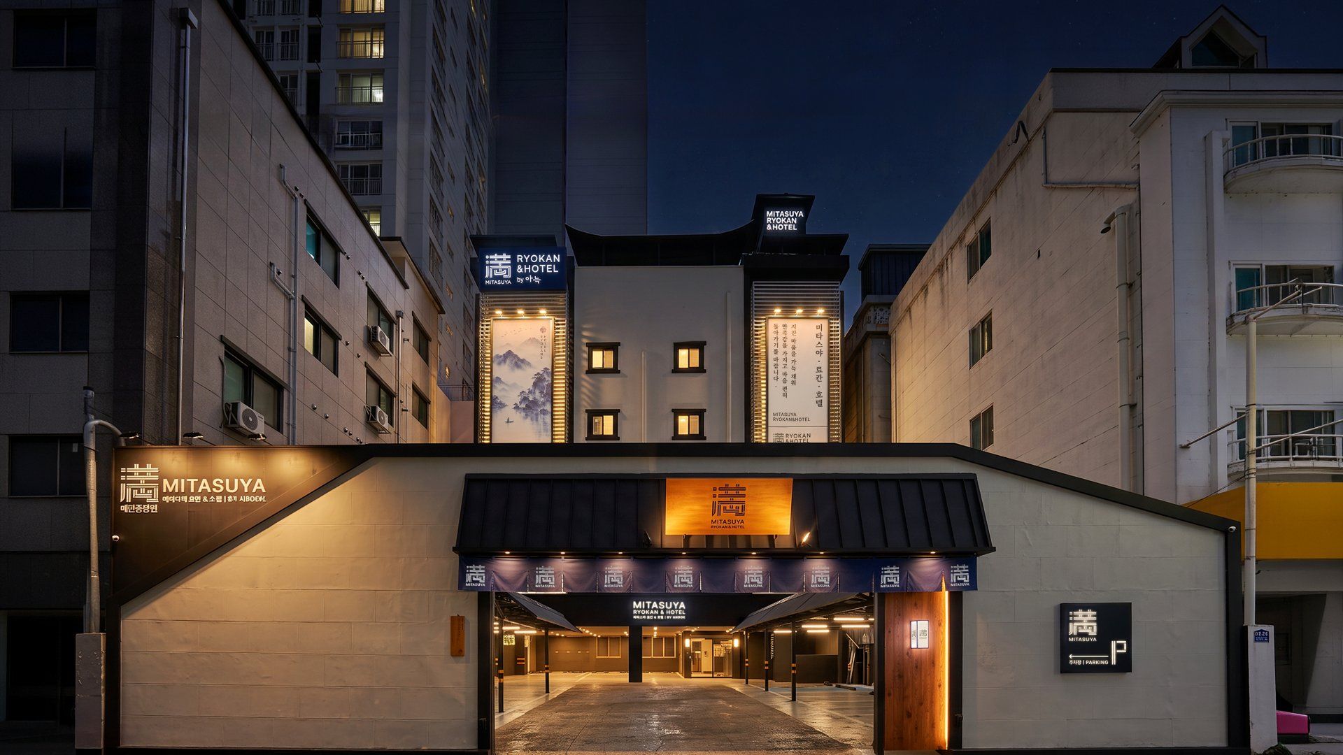 A hotel entrance with signage for 'MITSASUYA RYOKAN HOTEL' and 'MITSASUYA RYOKAN HOTEL by ANDREW.'