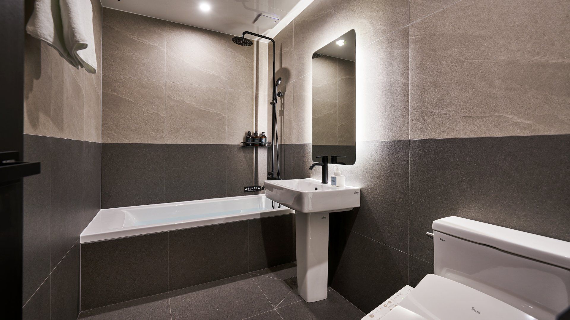 Un baño moderno con bañera, lavamanos e inodoro.