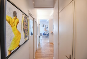 A hallway with a wooden floor leading to a dining area with chairs and a table. - Bail mobilité - Vue sur le Panier - Balcon - 2 ch (Marseille)
