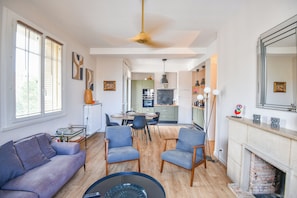 Uma sala de estar moderna com sofá, cadeiras, mesa de jantar e lareira.