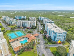 A resort with multiple buildings, a swimming pool, and a tennis court. - 🏖️Spacious 3BR Retreat: Pool, Tennis & Estuary Views | Oceanwalk 7-207🦈 (New Smyrna Beach)