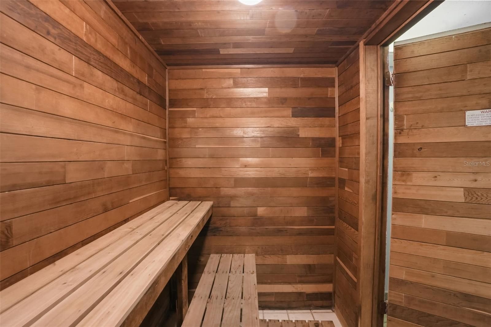 Un sauna avec des murs et des bancs en bois.