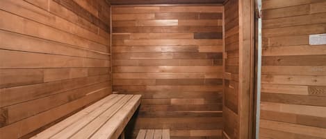 Una sala de sauna con paredes y bancos de madera.
