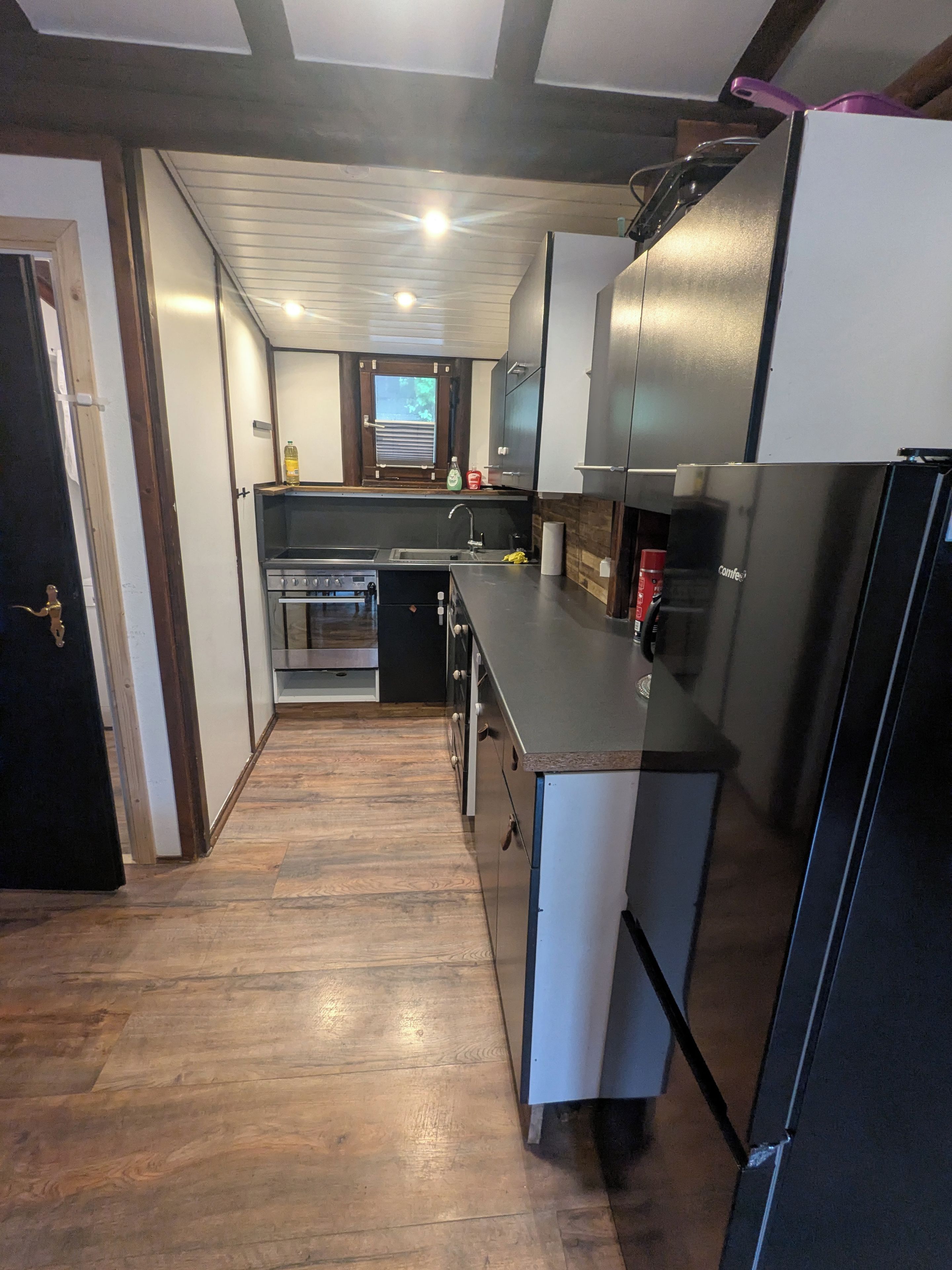 Eine Küche mit Kühlschrank, Herd, Spüle und Holzböden.