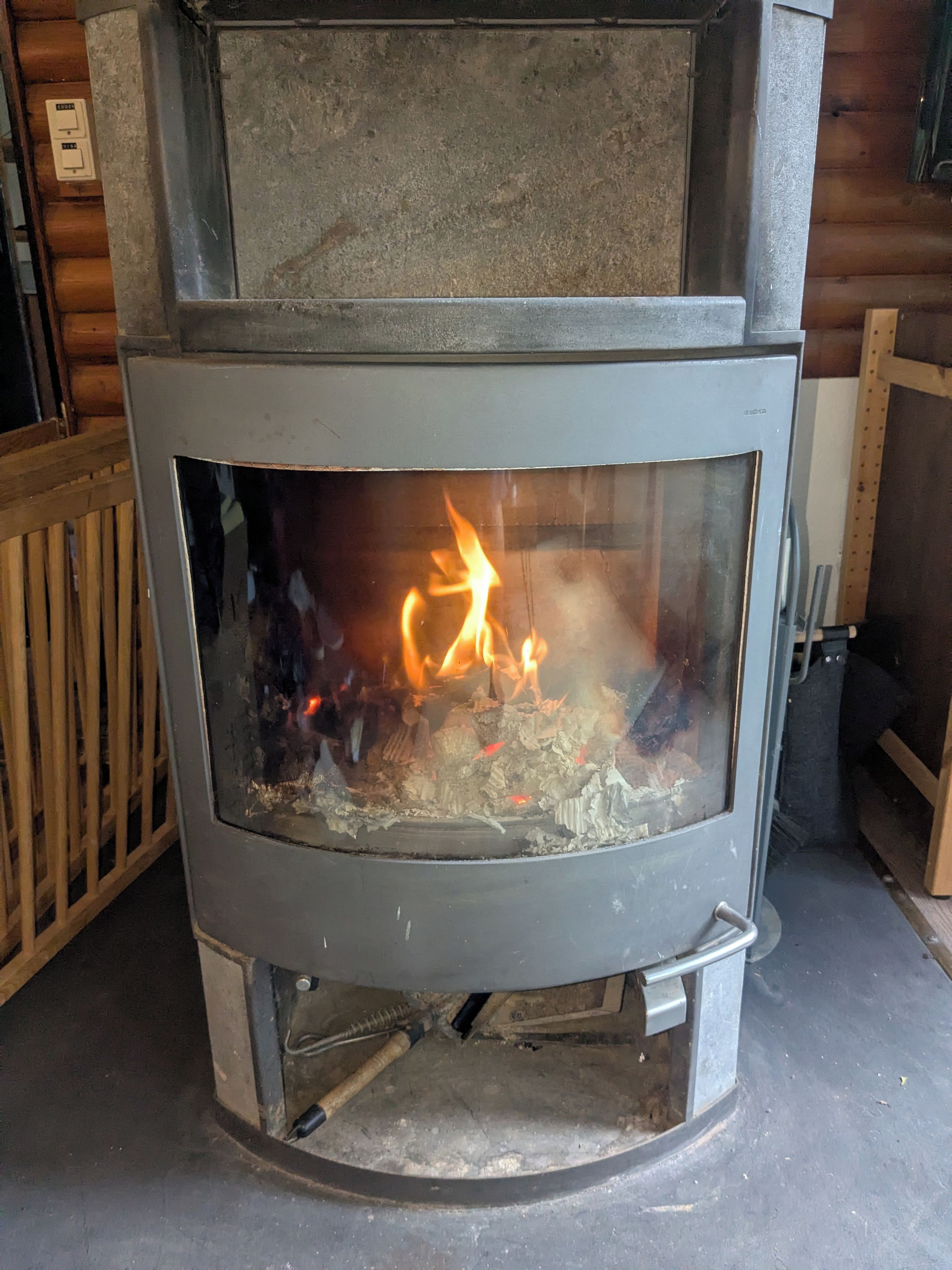 Puuuuni, jossa on lasinen etuosa, metallinen luukku ja metallinen kahva.