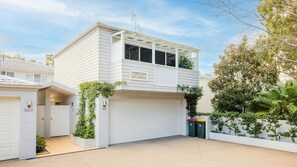 A two-story house with a garage, a covered porch, and a sign that reads 'High Tide'. - HighTide, 142 Sandy Point Rd - romantic getaway on the waterfront (Corlette)