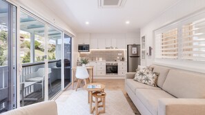 A modern kitchen with white cabinets, a stainless steel refrigerator, and a built-in oven. - HighTide, 142 Sandy Point Rd - romantic getaway on the waterfront (Corlette)