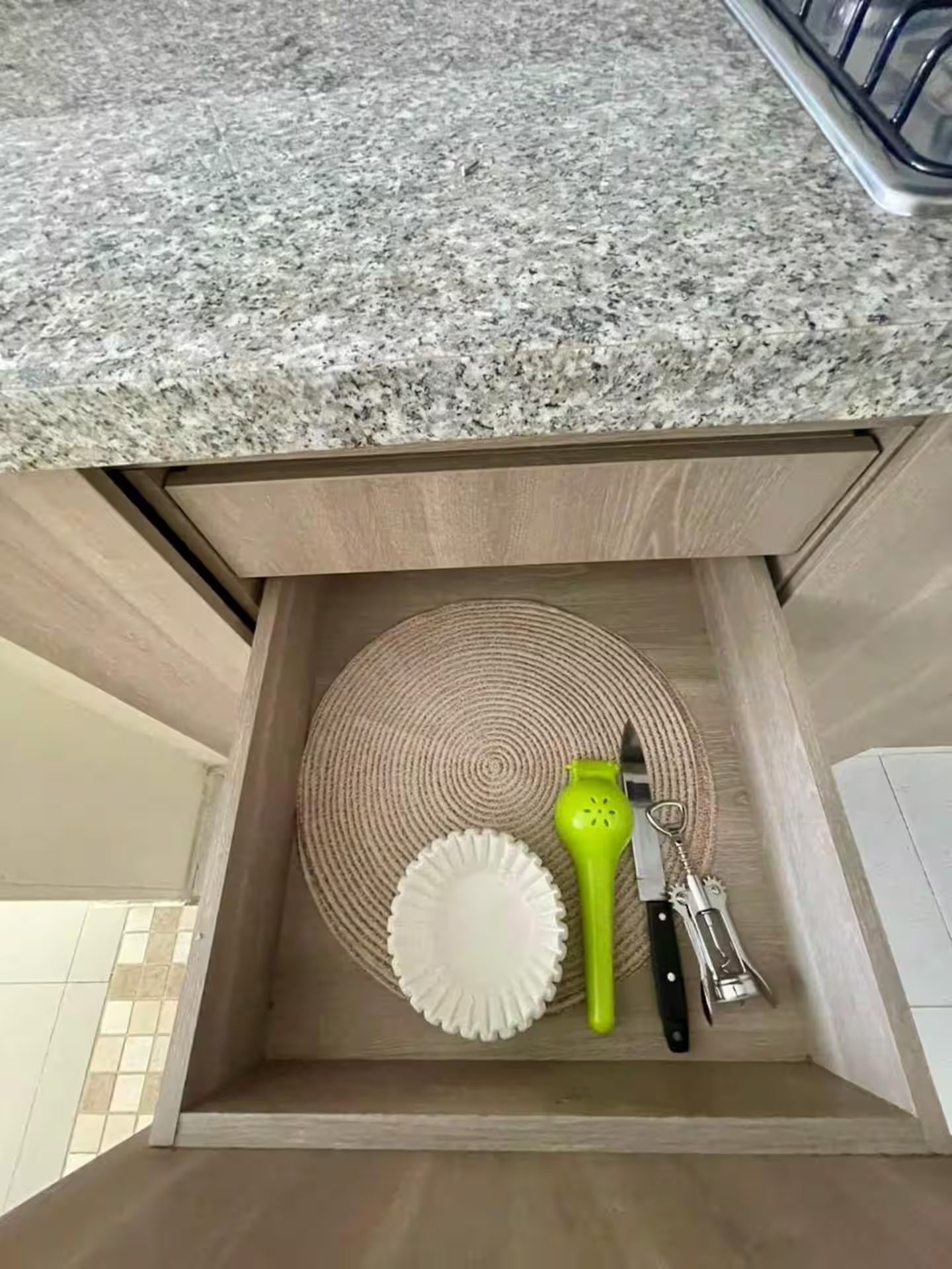 Eine Küchenschublade mit einer Arbeitsplatte aus Granit darüber.