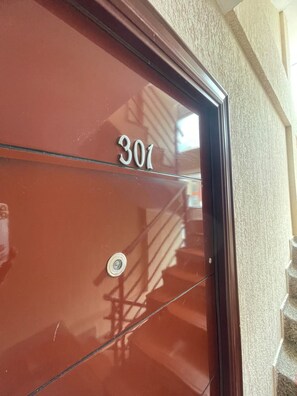 Una puerta roja con el número '301' y un cerrojo circular.