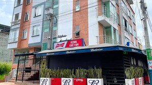 Un immeuble à plusieurs étages dont la façade comprend une devanture avec une enseigne Budweiser.