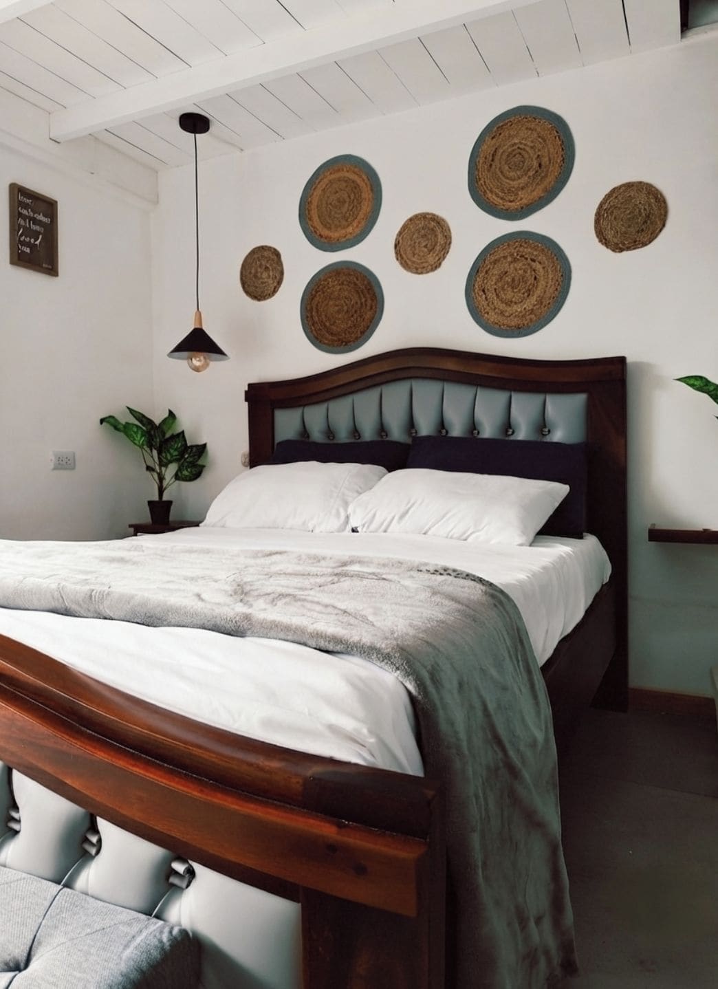 Een slaapkamer met een houten bed, een hanglamp en een wand met ronde geweven decoraties.