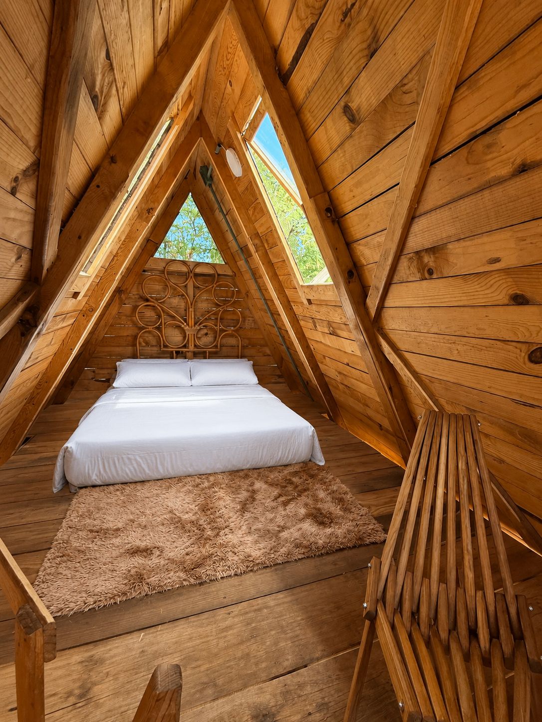 Une pièce en bois avec un lit, un tapis moelleux et une chaise en bois.