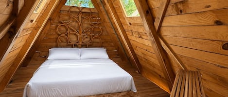 Une pièce en bois avec un lit, un tapis moelleux et une chaise en bois.