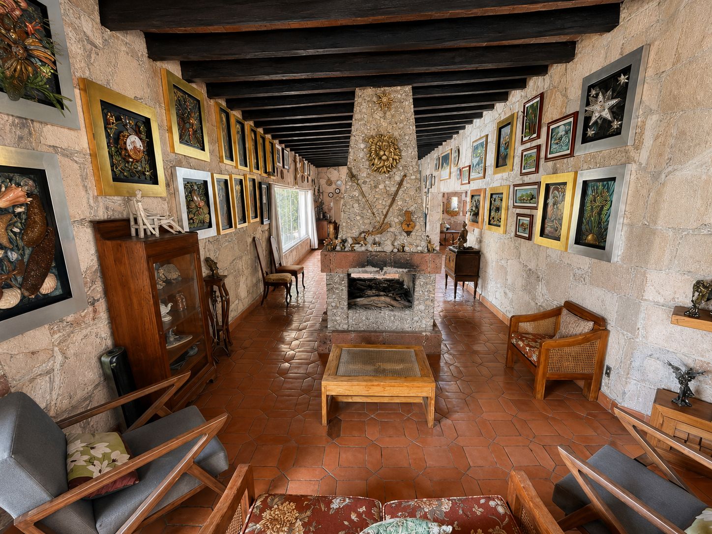 Un interior acogedor con chimenea de piedra, muebles de madera y obras de arte en las paredes.