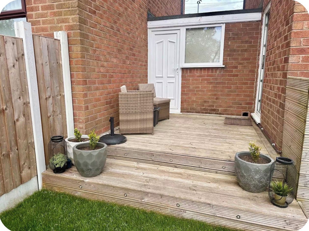 A patio with a wooden deck, a white door, and outdoor furniture.